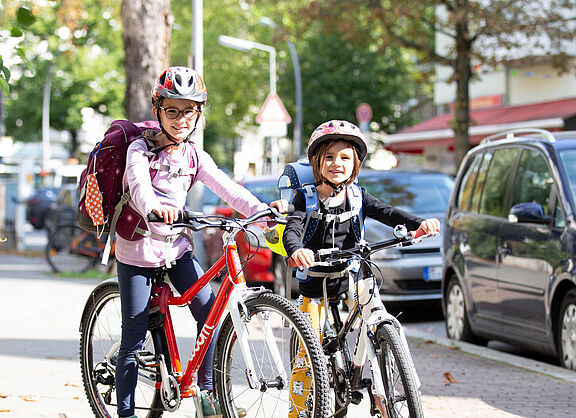 Mädchen mit Ranzen auf dem Fahrrad.